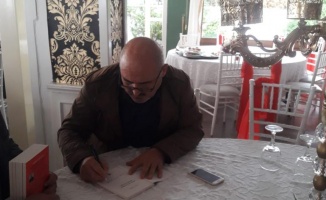 Şair Osman Adıgüzel kitabını imzaladı